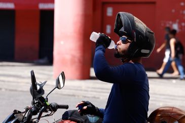 Tânia Rêgo/Agência Brasil Rio de Janeiro (RJ), 17/02/2024 -Transeuntes se protegem do forte calor nas ruas do centro da cidade. Cidade do Rio de Janeiro atinge nível 4 de calor. Marco é caracterizado por temperaturas que podem chegar a 44ºC Foto: Tânia Rêgo/Agência Brasil