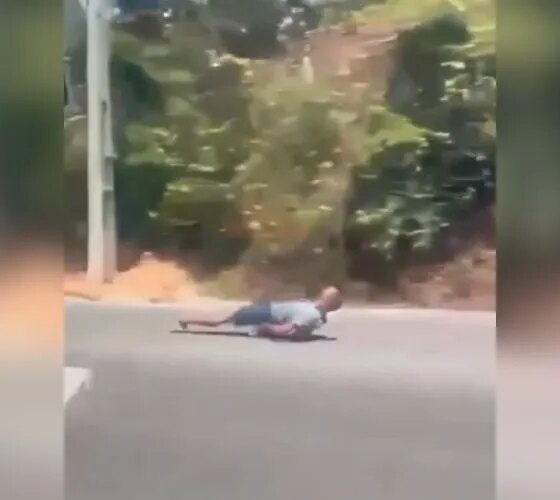 Homem desce deitado em skate no meio do trânsito em Manaus